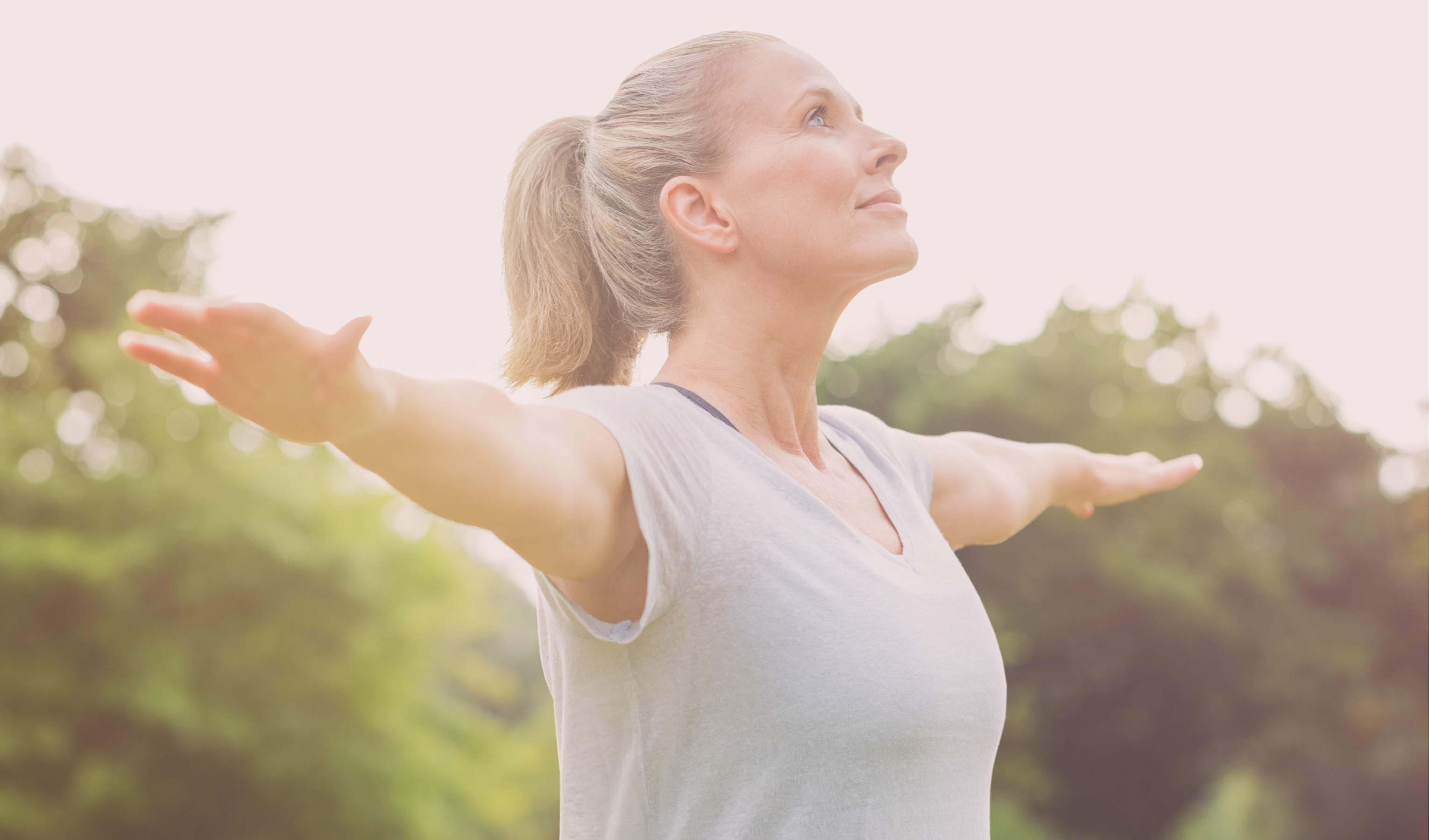 mature woman stretching arms out outdoors