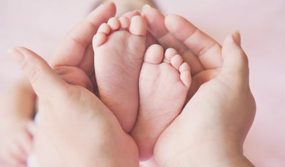 babies feet being held withing mothers hands
