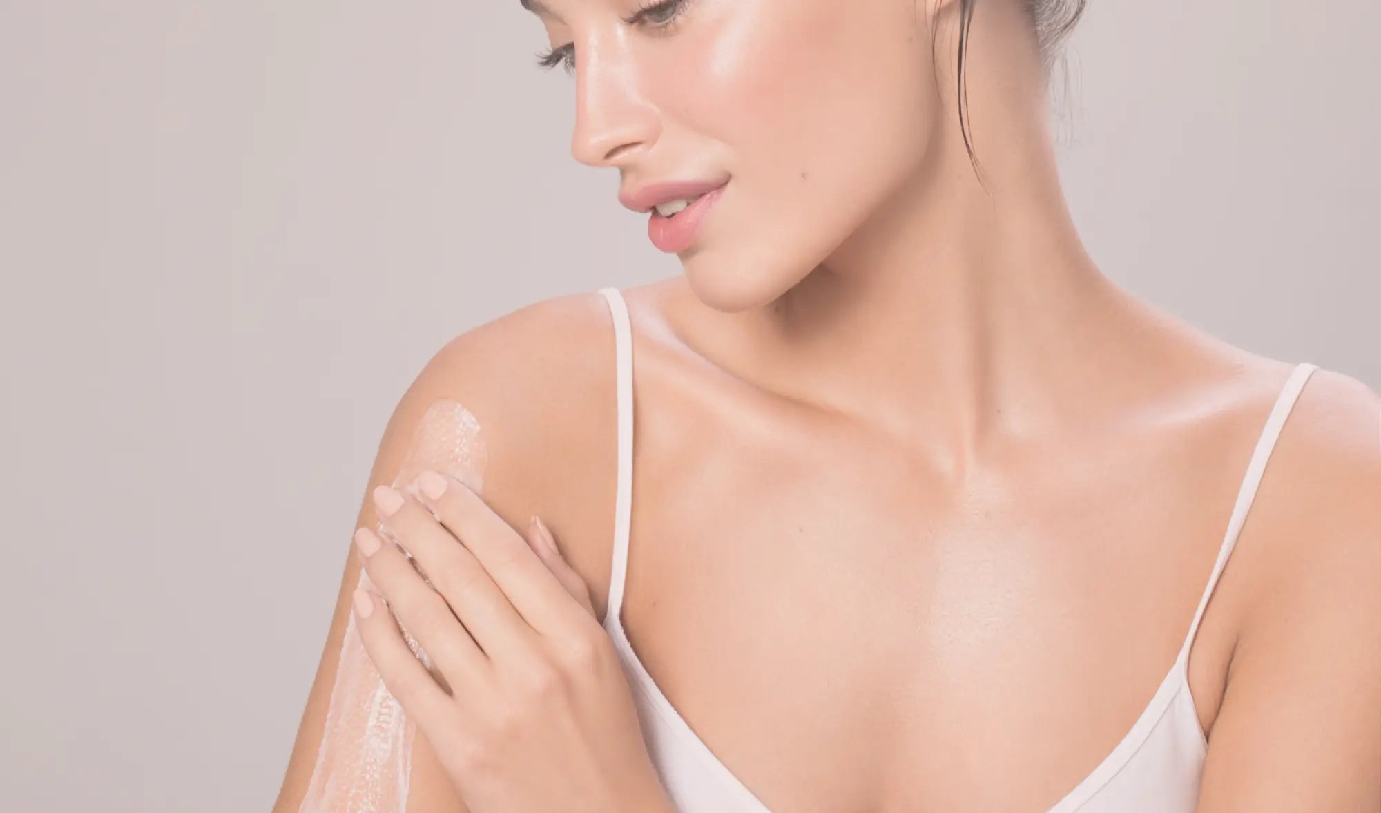 woman applying body moisturiser to body