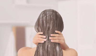 woman applying conditioner to hair