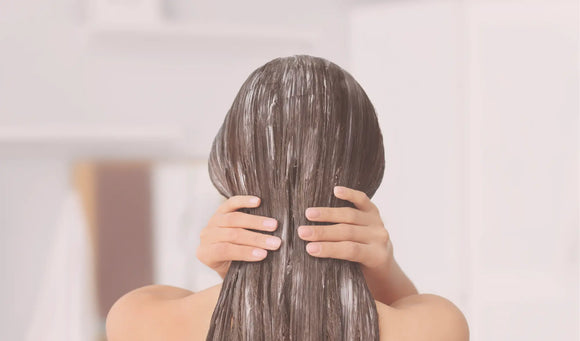 woman applying conditioner to hair