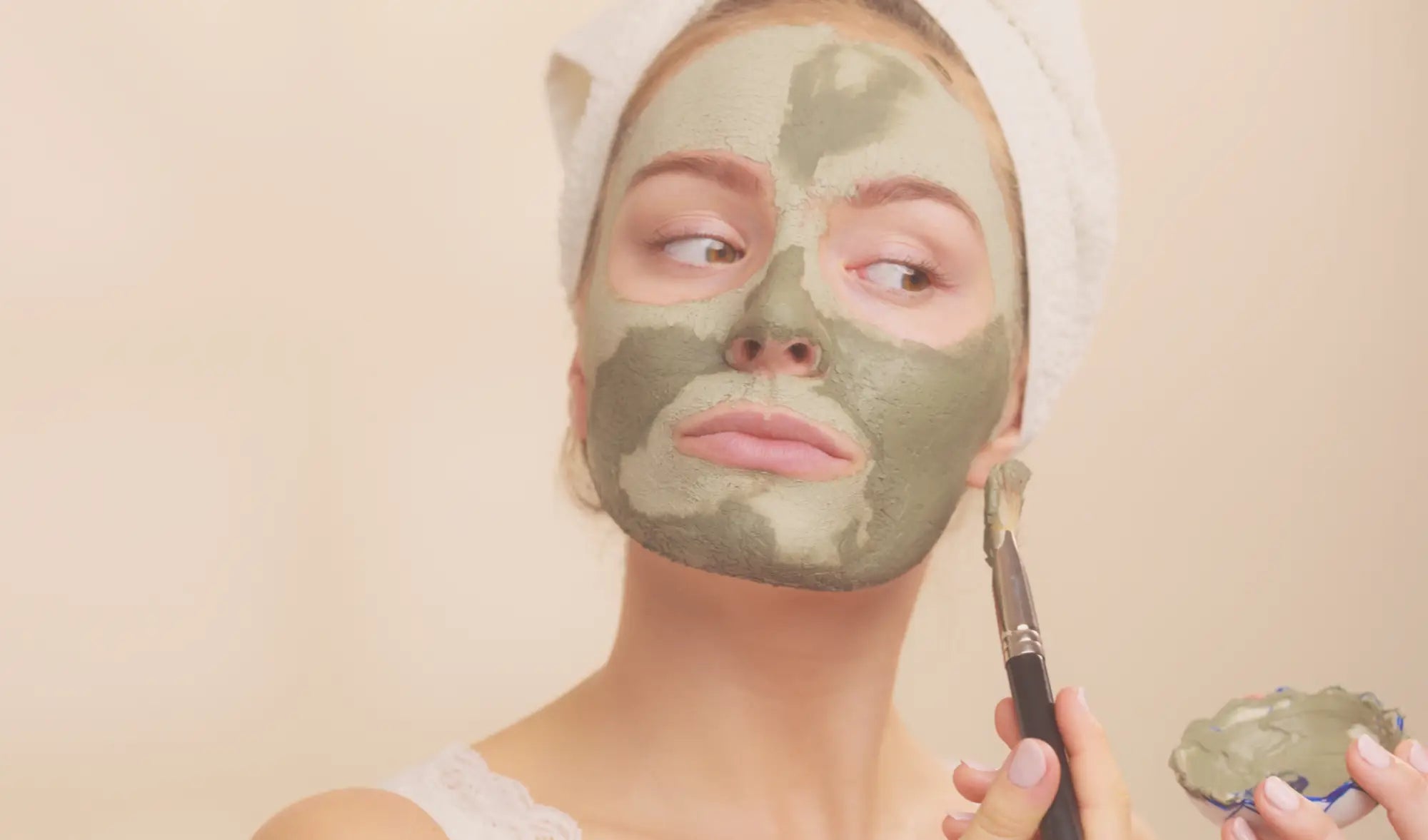 woman applying a clay mask with brush