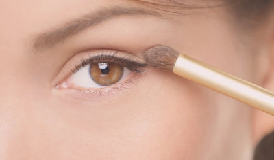 woman applying eye makeup with eyeshadow brush