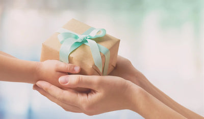 childs hands passing a gift over to mothers hands