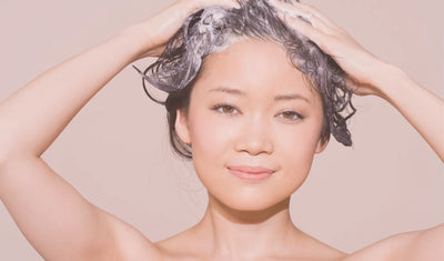 Woman applying shampoo to wet hair