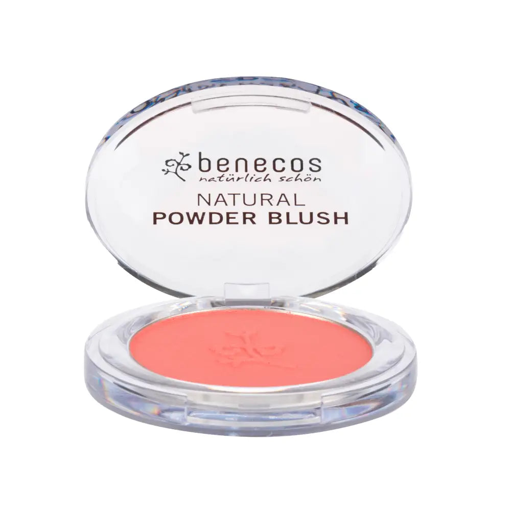 Coral-colored natural powder blush in a clear compact case with ’benecos’ branding.