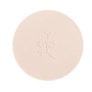 Circular beige pressed powder compact with an embossed design.