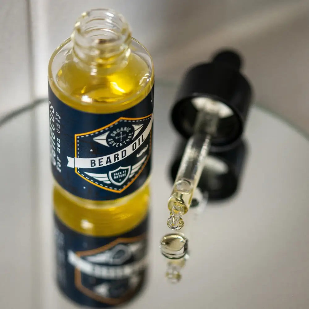 Glass bottle of beard oil with a navy blue label and dropper.