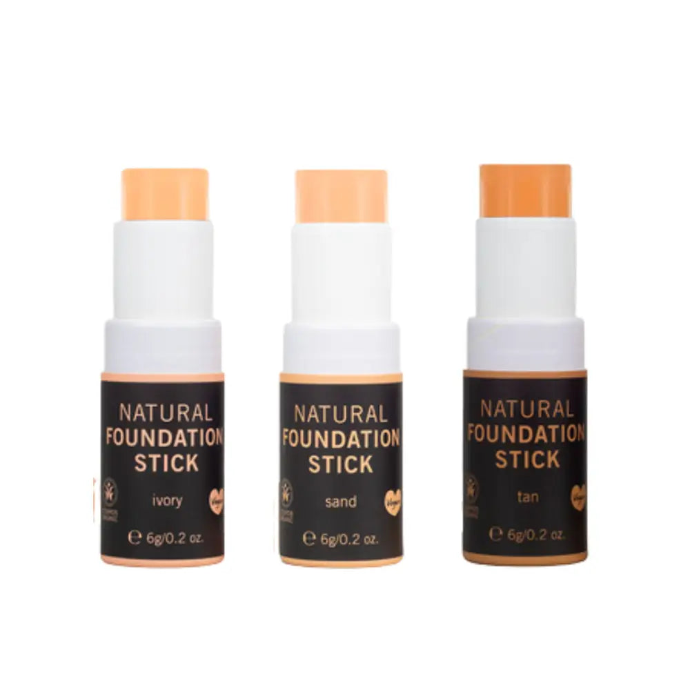 Three natural foundation makeup sticks in different skin tone shades labeled ivory, sand, and tan.