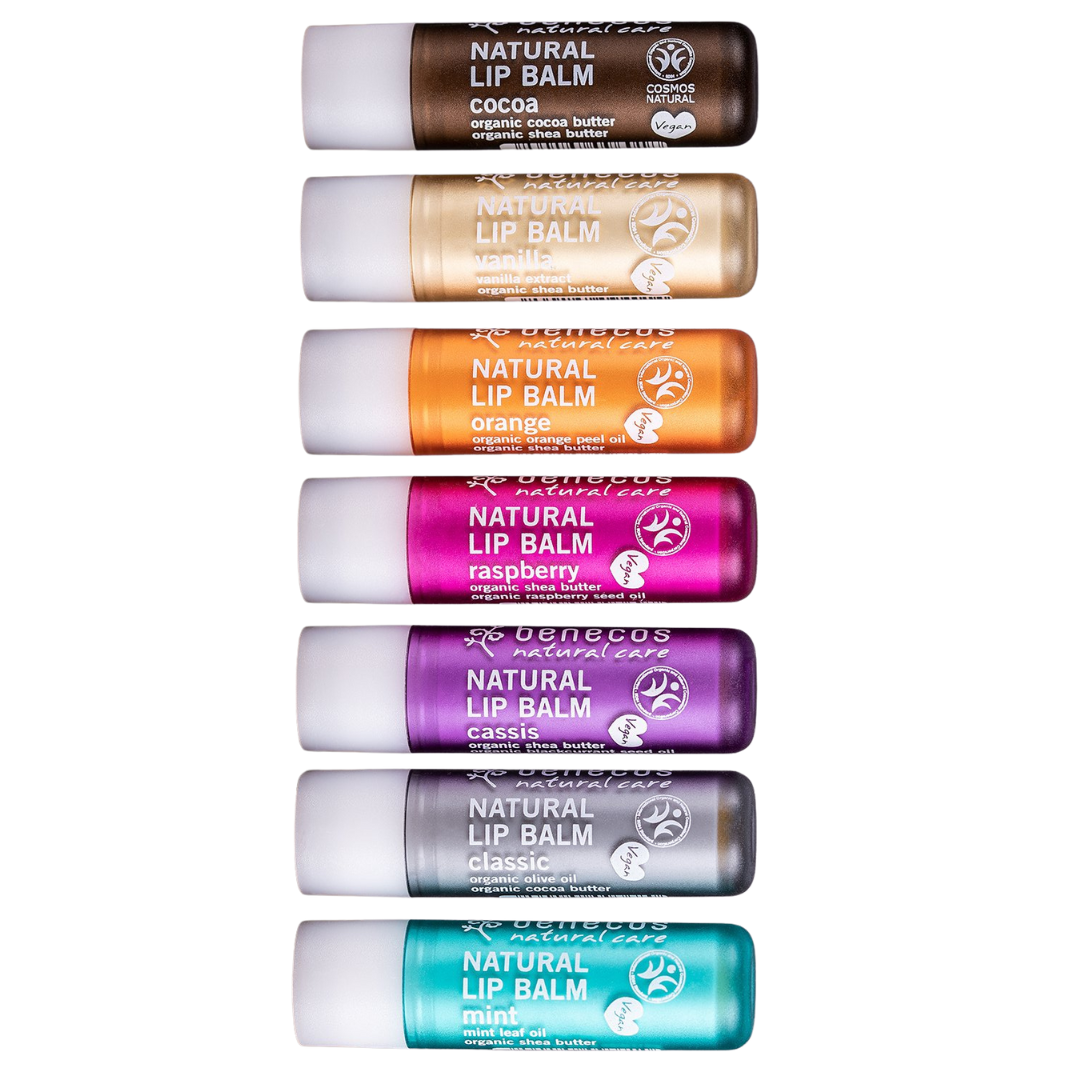 Benecos Natural Lip Balms with organic, vegan friendly ingredients. A flat lay of the seven flavours in order from top to bottom - cocoa, vanilla, orange, raspberry, cassis, classic and mint.