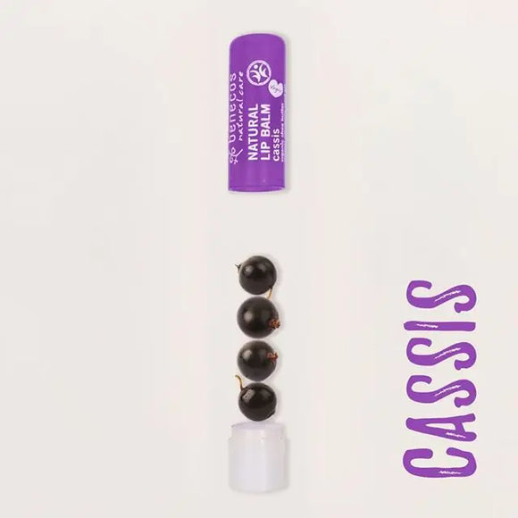 Purple lip balm tube with dark spherical candies or treats below it.