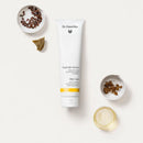 White tube of Dr. Hauschka Nach der Sonne after-sun product surrounded by small ingredient bowls.