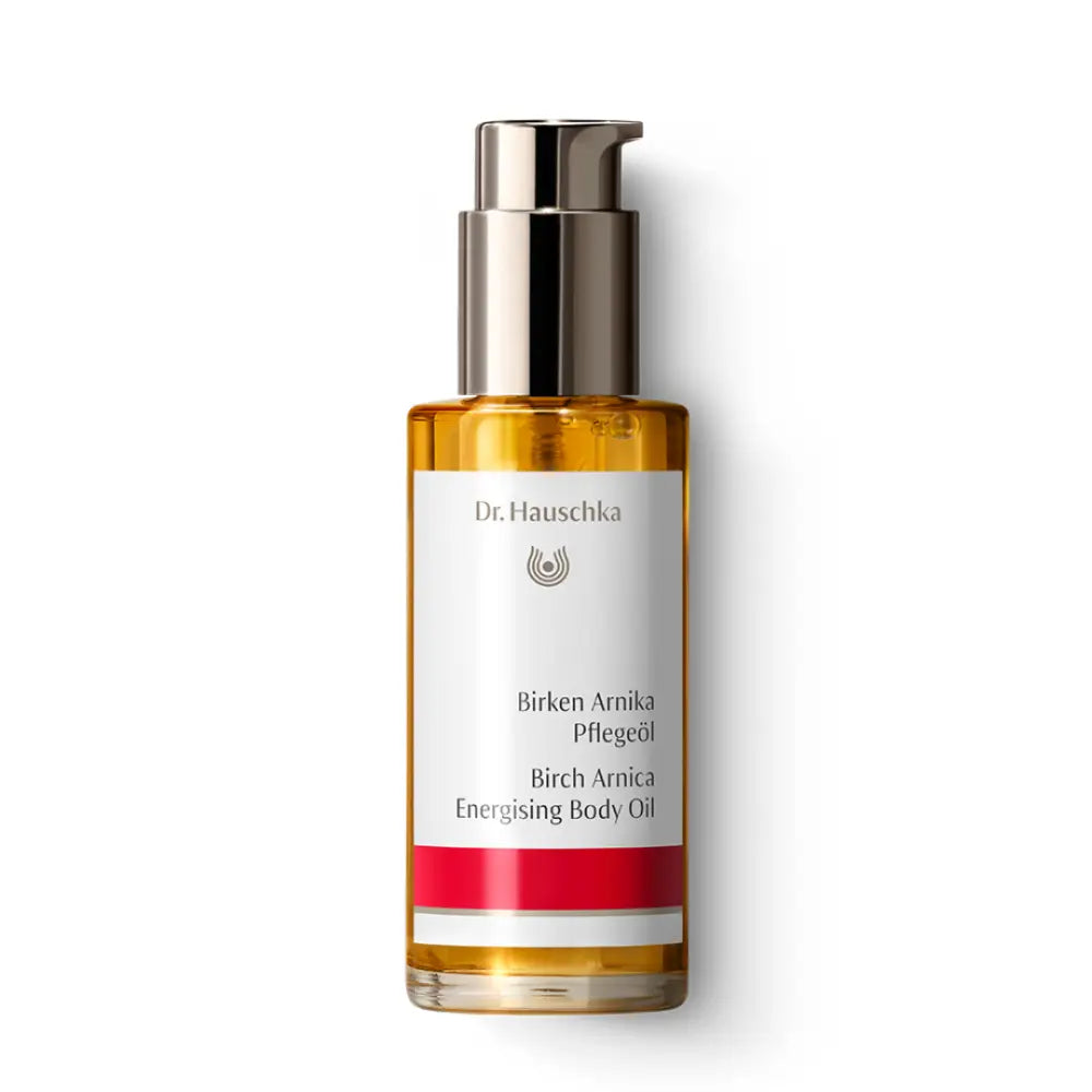 Glass bottle of Dr. Hauschka Birch Arnica body oil with a silver pump dispenser.