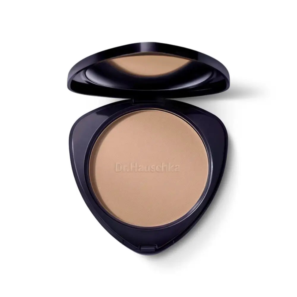 Compact powder makeup case with beige-colored pressed powder inside a black triangular container.