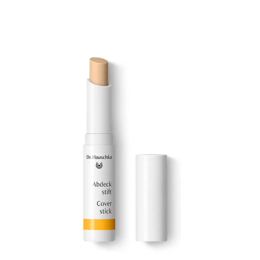 White cosmetic cover stick with a beige-colored tip and orange accent band.