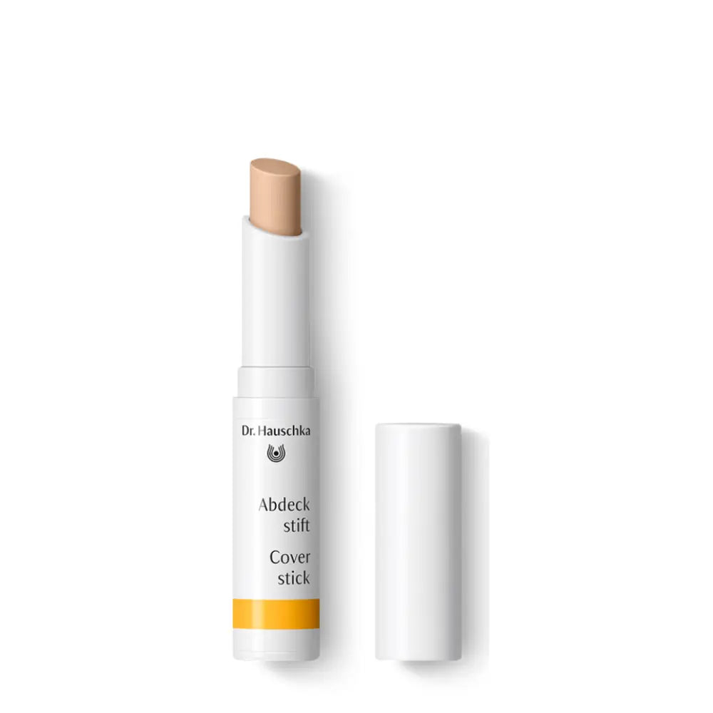 White cosmetic cover stick with a beige-colored tip and yellow accent on the label.