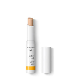 White cosmetic cover stick with a beige-colored tip and yellow accent on the label.