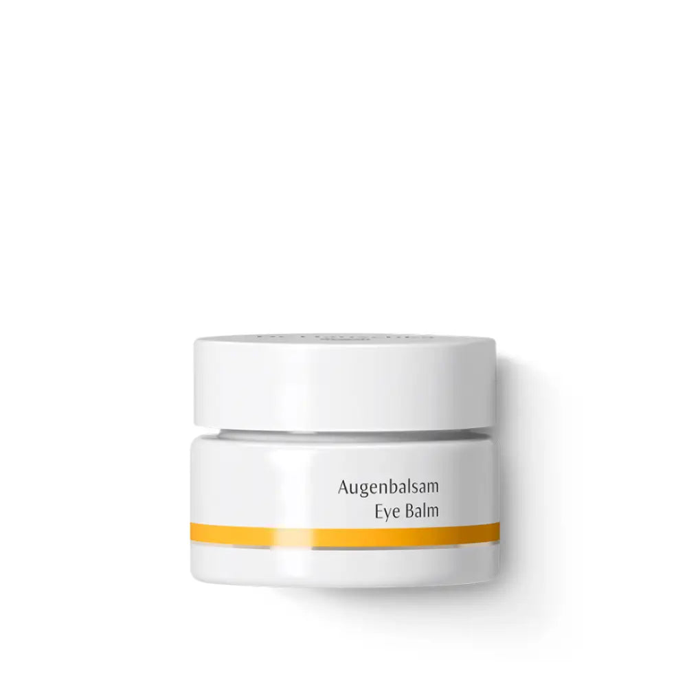 White cosmetic jar with a yellow stripe and ’Augenbalsam Eye Balm’ text.