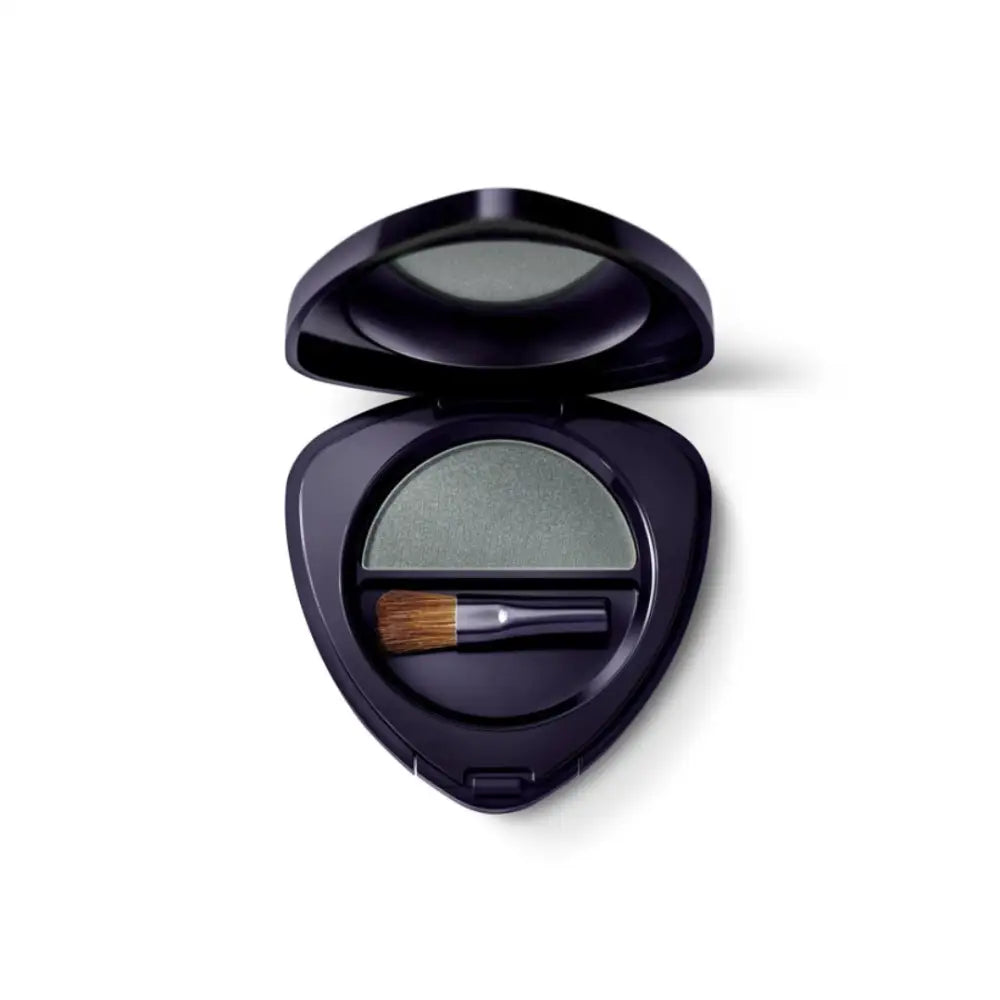 Black compact case containing gray eyeshadow and a small makeup brush.