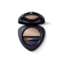 Black compact case containing beige eyeshadow and a small brush.