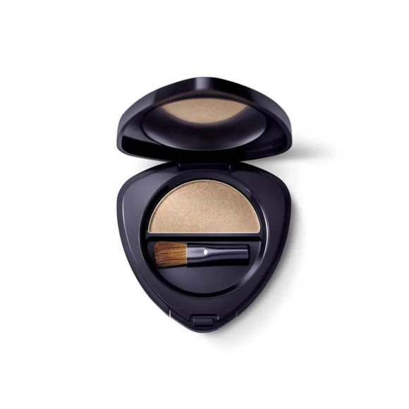 Black compact case containing beige eyeshadow and a small brush.