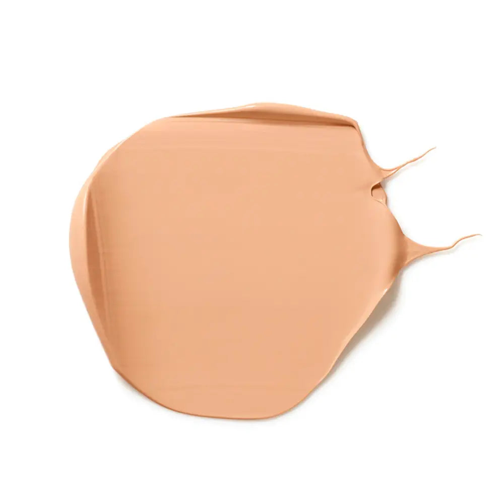 Smeared peach-colored liquid foundation or concealer makeup sample.