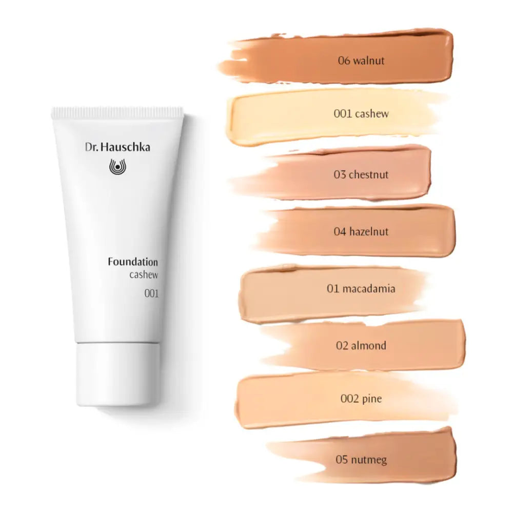 White tube of Dr. Hauschka foundation with swatches of different skin tone shades displayed beside it.