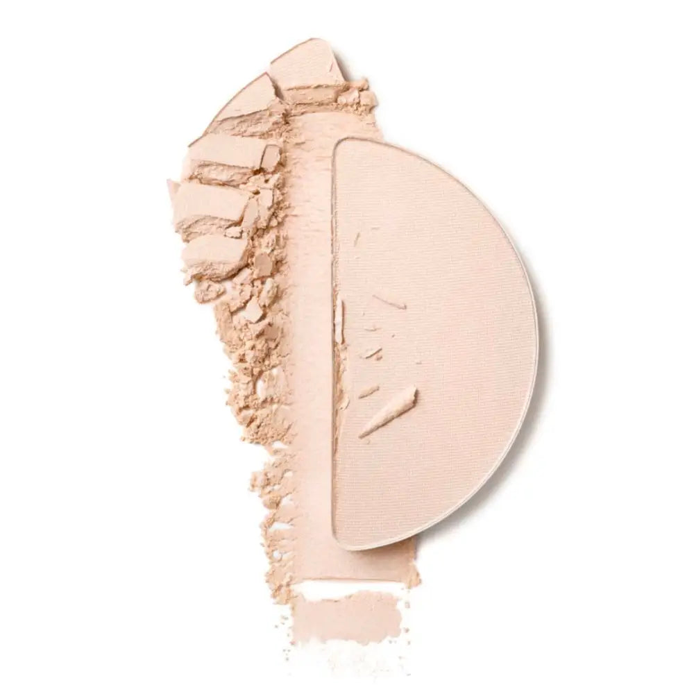 Half-circle of crushed beige face powder with a powdery smear.