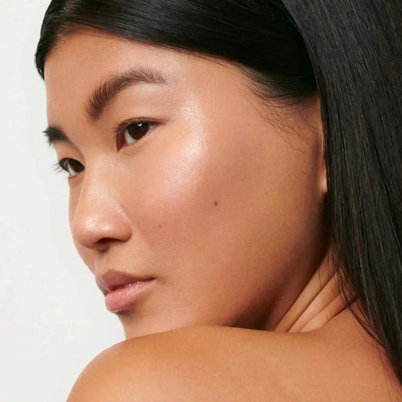 Side profile portrait showing glowing, natural-looking skin and dark straight hair.