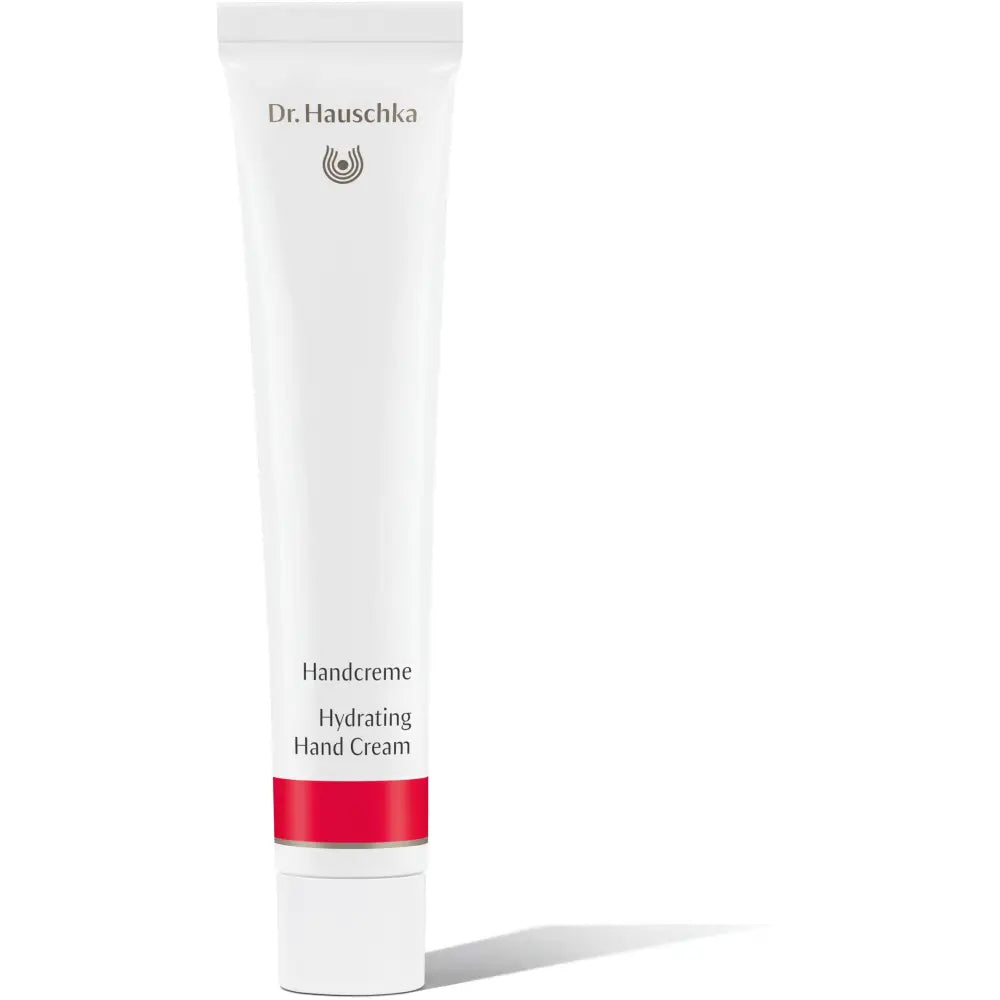 White tube of Dr. Hauschka Hydrating Hand Cream with a red band near the base.