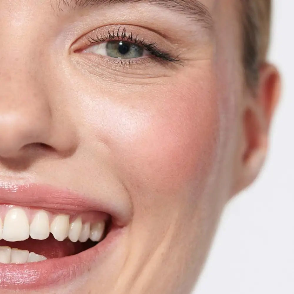 Close-up of a bright smile with healthy white teeth and rosy cheeks.