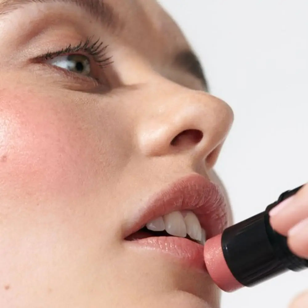 Pink lipstick being applied to lips.