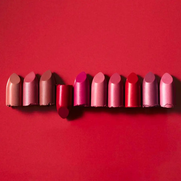Row of lipsticks in various shades of pink and red.
