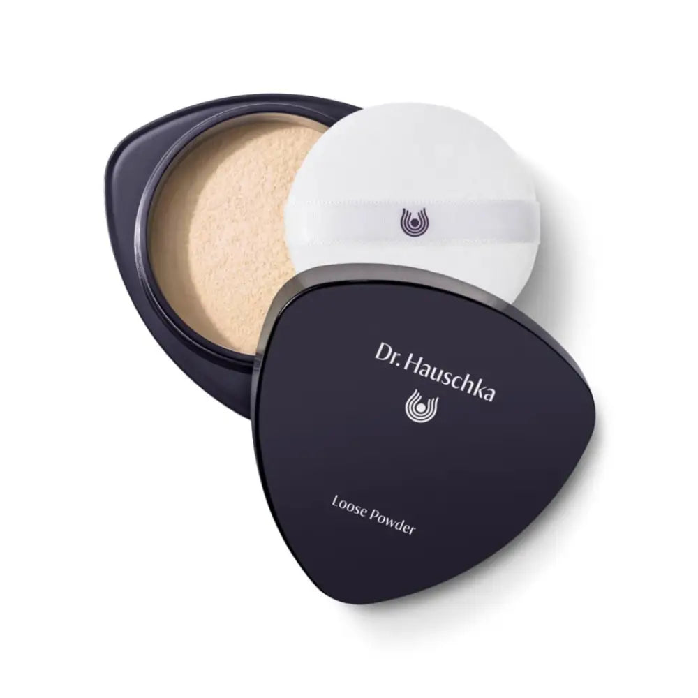 Dr. Hauschka loose powder compact with black triangular case and white powder inside.