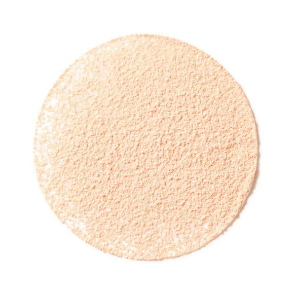 Circular disc of light peachy-beige powder with a finely textured surface.