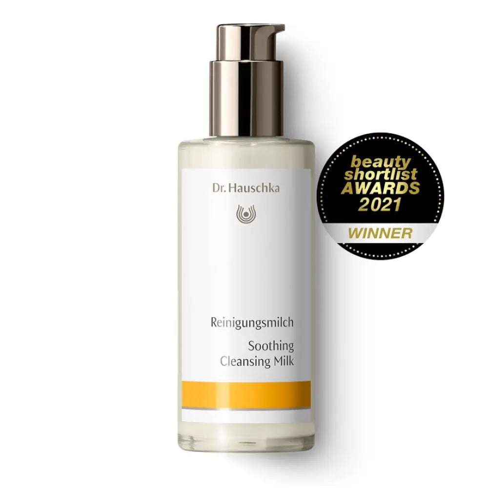 White bottle of Dr. Hauschka Soothing Cleansing Milk with a silver pump dispenser and orange accent band.