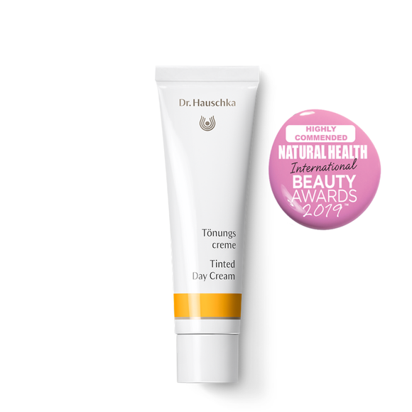 White tube of Dr. Hauschka Tinted Day Cream with a pink award badge.