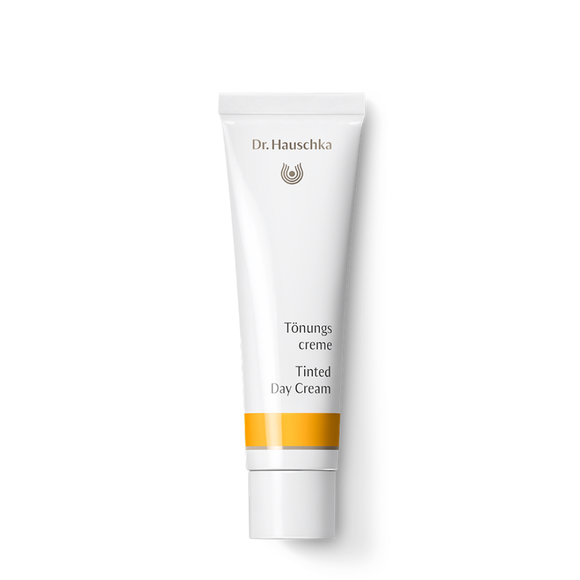 White tube of Dr. Hauschka Tinted Day Cream with yellow accent stripe.