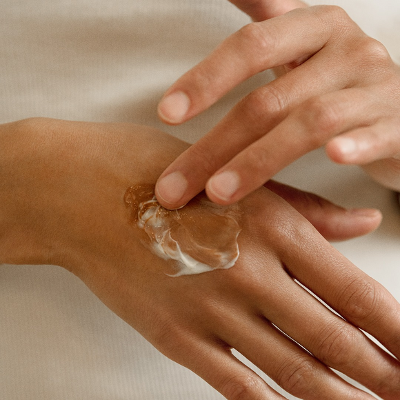 Hand applying lotion.