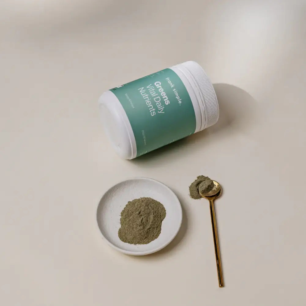 Green-labeled white cylindrical container with powder and a gold spoon.