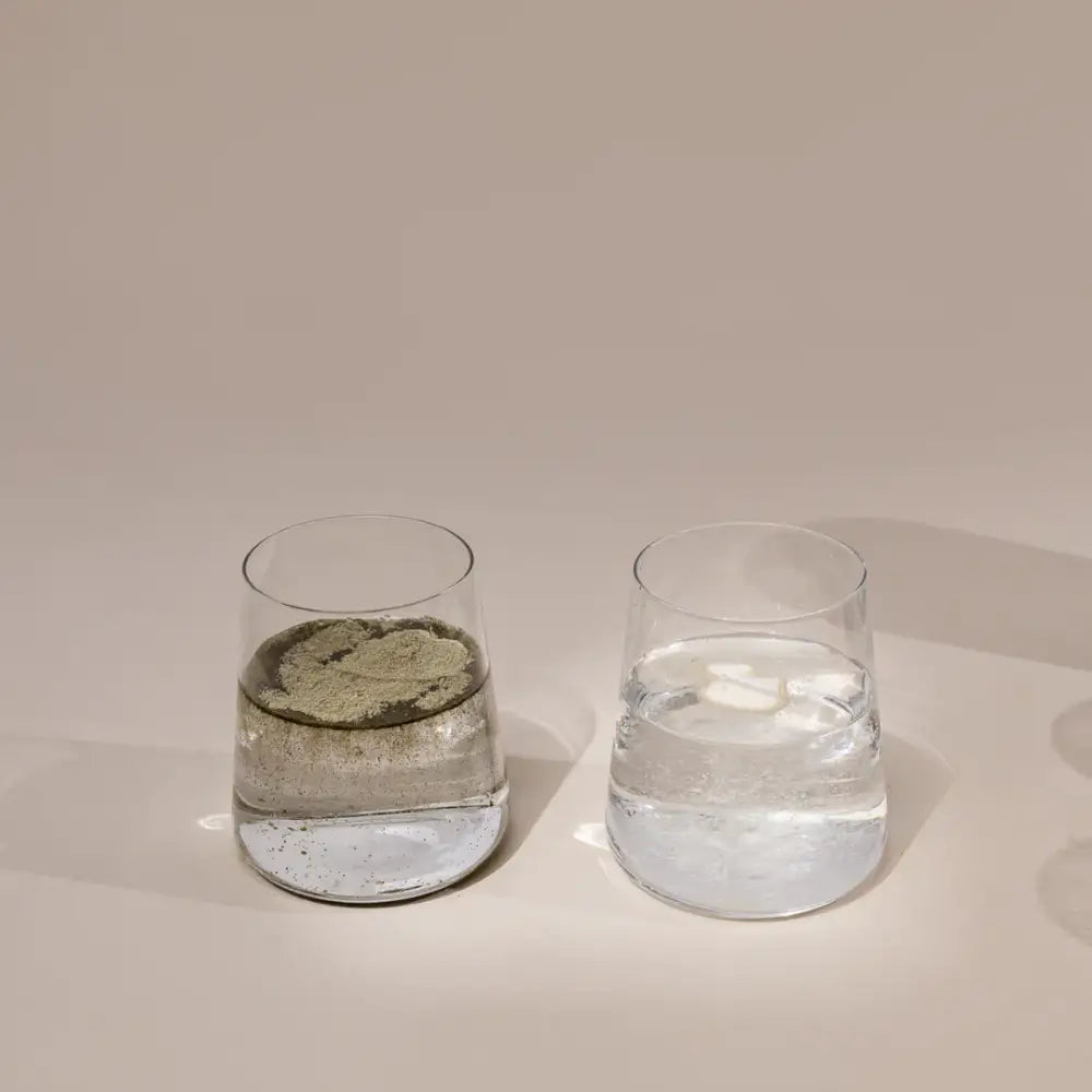 Two clear drinking glasses partially filled with liquid.