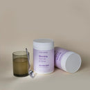 Purple and white supplement container labeled ’Morning Get Up & Glow’ with a glass of liquid and spoon beside it.