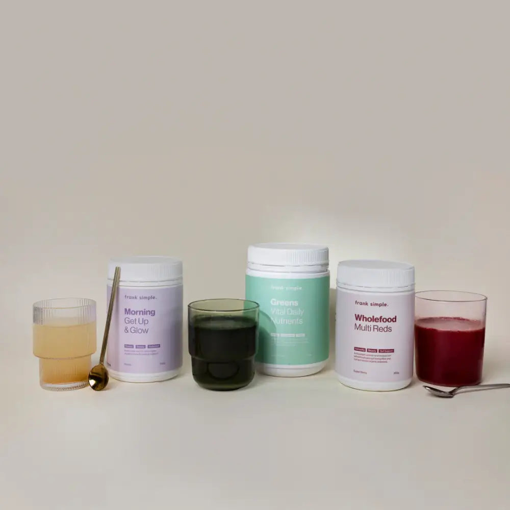 Collection of supplement powder containers and mixed beverages in glasses.