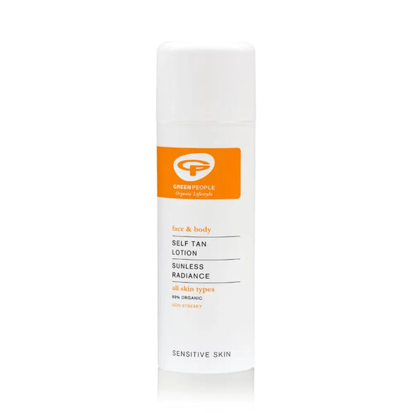 White bottle with orange labeling containing self-tanning lotion for sensitive skin.