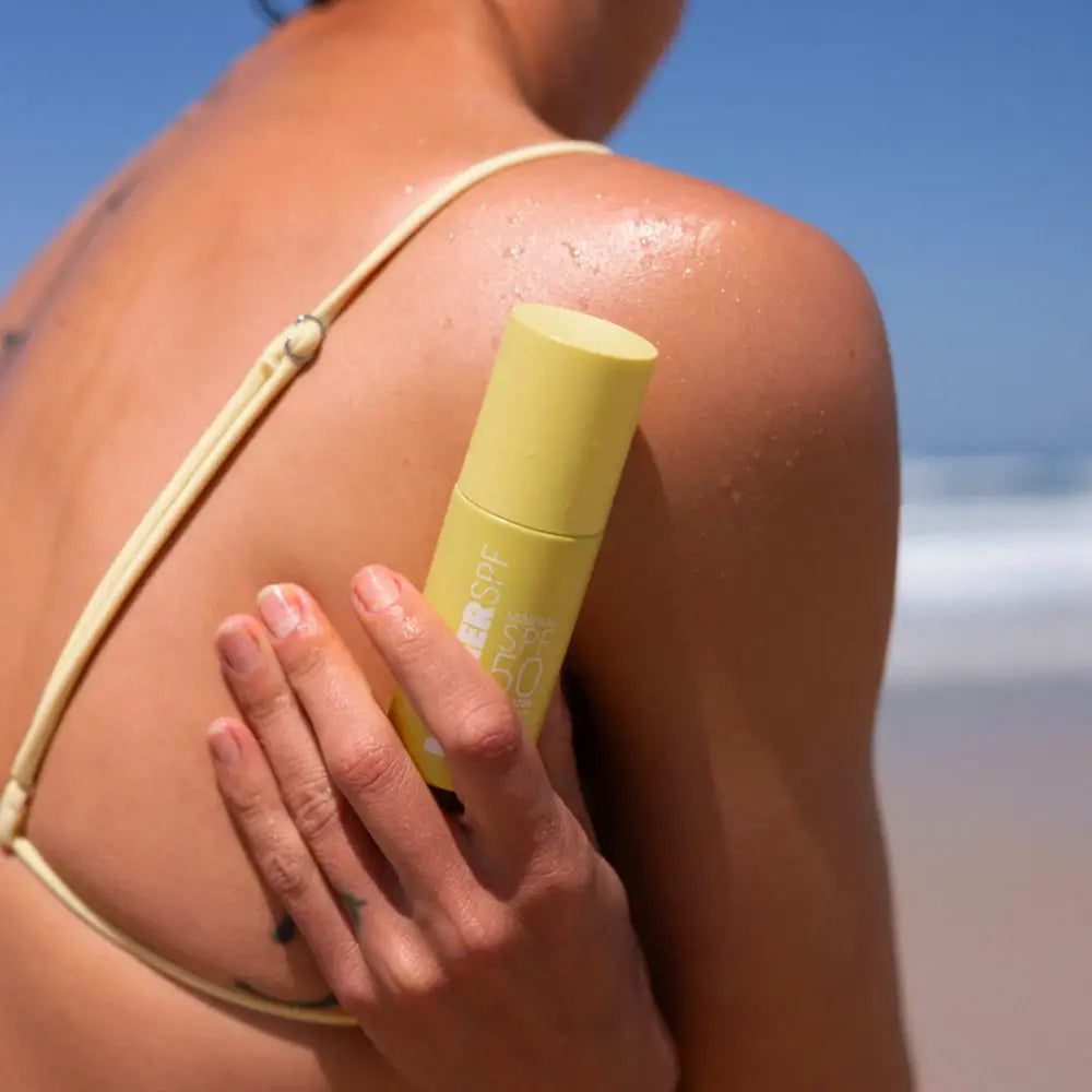 Yellow sunscreen stick being applied to sunburned skin.