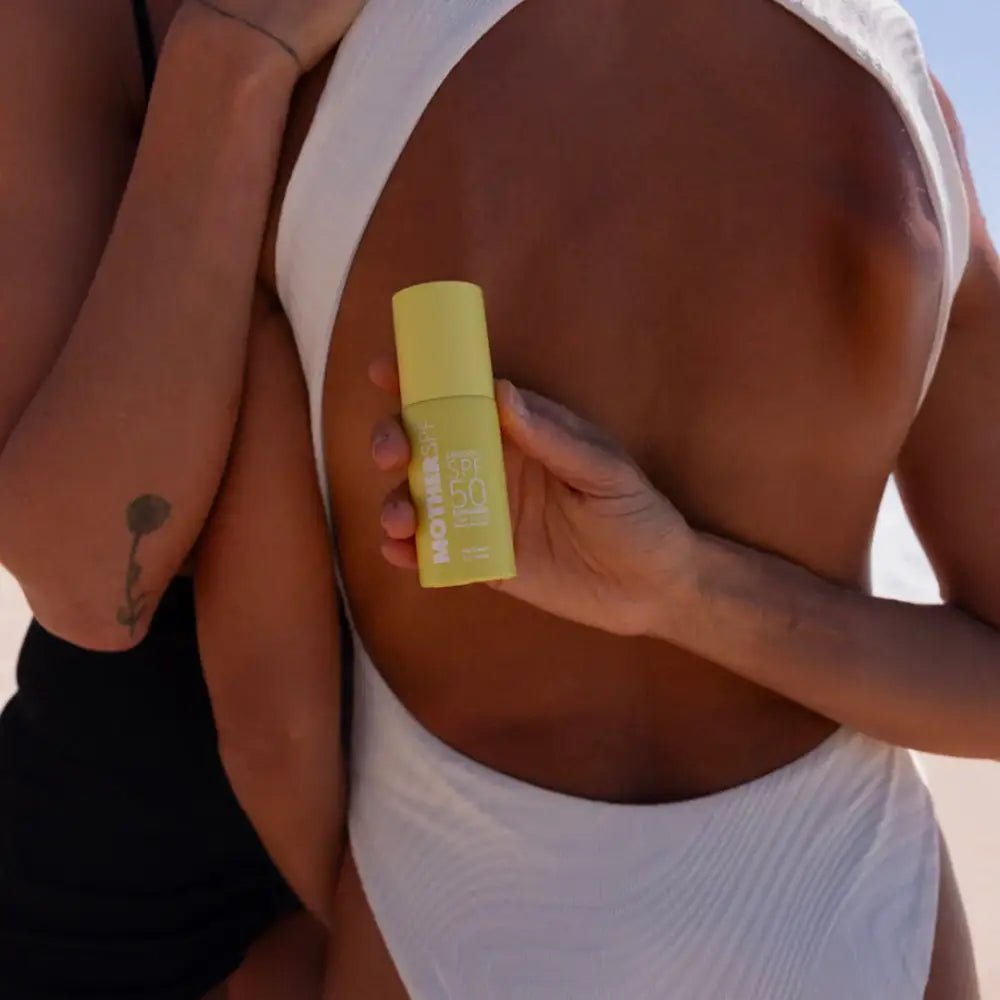 Yellow sunscreen stick being applied to skin.