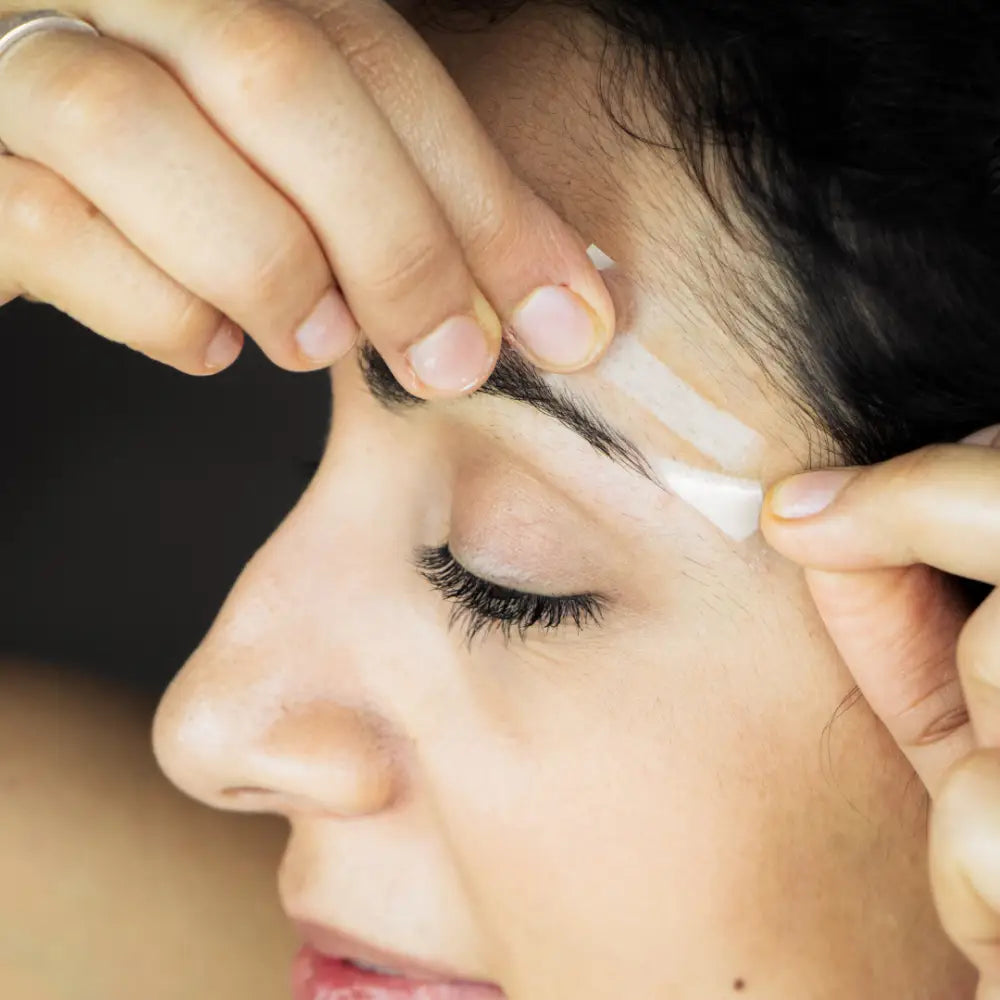 Eyebrow waxing or threading beauty treatment in progress.