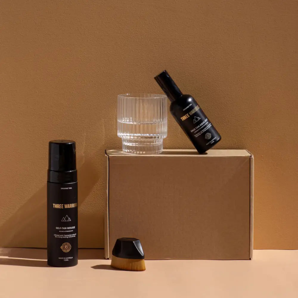 Cardboard box with skincare products and a glass tumbler arranged on top.