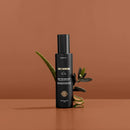 Black cylindrical bottle with minimalist branding and text.