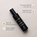 Black skincare bottle with labeled ingredients including Tasmanian Olive Oil, Hyaluronic Acid, Aloe Vera, and Marine Collagen.